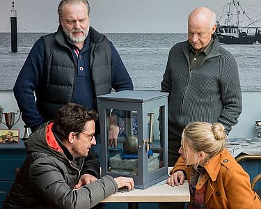 "Reiff fr die Insel" - "Katharina und der groe Schatz": Szenenfoto (vorne) mit Oliver Mommsen als Wissenschaftler Jens Jeschen, Tanja Wedhorn als Katharina Reiff sowie (hinten) Jan-Gregor Kremp als Thies Quedens und Dietrich Hollinderbumer als dessen Vater Helge; mit freundlicher Genehmigung von Pidax-Film, welche die Reihe im Oktober 2021 auf DVD herausbrachte.