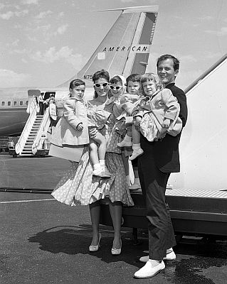 Pat Boone mit Ehefrau Shirley sowie den vier Kindern (v.l.n.r.) Lindy, Cherry, Laurie und Debbie am 01.06.1959 bei Ankunft auf dem Flughafen von Los Angeles; Quelle: Wikimedia Commons von "UCLA Library Digital Collection"; Urheber: "Los Angeles Times"; Lizenz: CC BY 4.0 Deed
