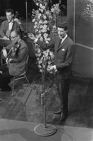 Rudi Carrell am 9.Februar 1960 beim Vorentscheid zum "Eurovision Song Contest" in Hilversum; Rechteinhaber: Nationaal Archief (Den Haag, Rijksfotoarchief; Bestandsnummer: 911-0172); Urheber/Fotograf: Harry Pot / Anefo; Quelle: Wikimedia Commons; Lizenz:www.gahetna.nl/over-ons/open-data / CC BY-SA 3.0 NL