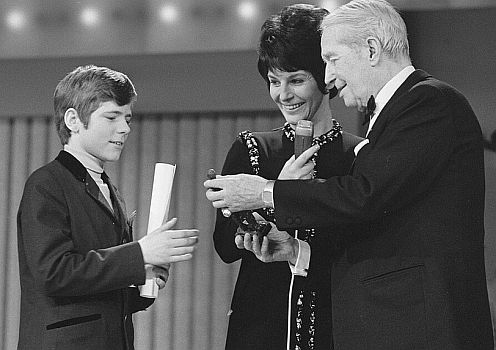 Heintje am 27.02.1970 mit Maurice Chevalier und Mies Bouwman bei der Preisverleihung des "Edison Award" anlässlich der "Grand Gala du Disque" in Amsterdam; Rechteinhaber: Nationaal Archief  (Den Haag, Rijksfotoarchief; Bestandsnummer: 923-3007); Urheber/Fotograf: Rob Mieremet / Anefo; Quelle: Wikimedia Commons (Ausschnitt des Originalfotos); Lizenz: CC BY-SA 3.0 NL bzw. CC0 1.0 (Verzicht auf das Copyright)