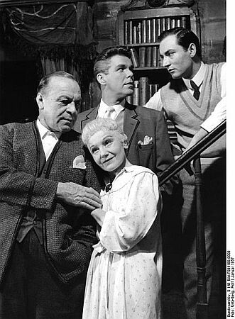 Gastspiel des Düsseldorfer Schauspielhauses im Stadttheater Bad Godesberg (15.-17.1.1957): Eines langen Tages Reise in die Nacht (Long day's journey into night), Schauspiel von Eugene O'Neill (Deutsch von Ursula und Oscar Fritz Schuh); Regie: Karl Heinz Stroux; Bühnenbild und Kostüme: Ita Maximowna; Von links nach rechts: Paul Hartmann (James Tyrone), Elisabeth Bergner (Mary Cavan Tyrone), Heinz Drache (James Thyrone jr., ihr ältester Sohn), Martin Benrath (Edmund Tyrone, ihr jüngster Sohn); Schauplatz: Wohnzimmer im Sommerhaus der Thyrones an einem Augusttag des Jahres 1912; Quelle: Bilddatenbank Deutsches Bundesarchiv, B 145 Bild-F004180-0008; Fotograf: Rolf Unterberg / Datierung: Januar 1957 / Lizenz CC-BY-SA 3.0. 