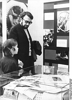 Foto: Wolfgang Kieling 1968;  Historische Originalbeschreibung: 30.2.1968 Berlin, Vietnam-Ausstellung: Der Schauspieler Wolfgang Kieling, besuchte mit seiner Tochter Anett am20.3.1968 die Vietnam-Ausstellung in der Berliner Friedrichstrasse. Er informierte sich über die Solidaritätsbeweise der Bevölkerung derDDR für das heldenhaft kämpfende vietnamesische Volk. Quelle: Deutsches Bundesarchiv, Digitale Bilddatenbank, Bild 183-G0320-0029-001; Fotograf: Eva Brüggmann / Datierung: 20. 3.1968 / Lizenz CC-BY-SA 3.0.