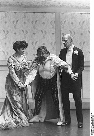 Fritzi Massary (links) und der Charakterkomiker Joseph Giampietro (18661913; rechts) in der Ausstattungs-Posse  "Die Heren von Maxim" im Berliner Metropol-Theater; Quelle: Deutsches Bundesarchiv, Digitale Bilddatenbank, Bild 183-H26728; Fotograf: Unbekannt / Datierung: 1904/1913 ca. / Lizenz CC-BY-SA 3.0.