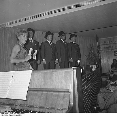 "Mnchner Abend" 1964 mit der "Mnchner Lach- und Schiegesellschaft" bei der Landesvertretung Bayern in Bonn;  v.l.n.r.: Ursula Noack, Jrgen Scheller, Hans Jrgen Diedrich, Dieter Hildebrandt, Klaus Havenstein; Quelle: Deutsches Bundesarchiv, Digitale Bilddatenbank, B 145 Bild-F018380-0004; Fotograf: Egon Steiner / Datierung: 25.06.1964 / Lizenz CC-BY-SA 3.0.