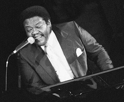 Fats Domino 1992 anlässlich eines Konzerts im französischen Deauville; Quelle: Wikipedia bzw. Wikimedia; Urheber: Roland Godefroy, Foto  cropped by Erik Baas; Lizenz CC-BY-SA 3.0.; Diese Datei ist unter der Creative Commons-Lizenz Namensnennung 3.0 Unported lizenziert. Es ist erlaubt, die Datei unter den Bedingungen der GNU-Lizenz für freie Dokumentation, Version 1.2 oder einer späteren Version, veröffentlicht von der Free Software Foundation, zu kopieren, zu verbreiten und/oder zu modifizieren; es gibt keine unveränderlichen Abschnitte, keinen vorderen und keinen hinteren Umschlagtext. Der vollständige Lizenztext ist im Kapitel GNU-Lizenz für freie Dokumentation verfügbar. 