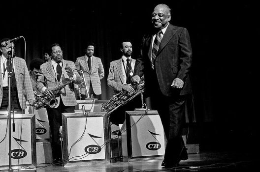 Count Basie 1974 mit seiner Band in Hamburg; Urheber: Heinrich Klaffs (www.hklaffs.de); Quelle: Wikimedia Commons von www.flickr.com; Lizenz: CC-BY-SA 2.0.