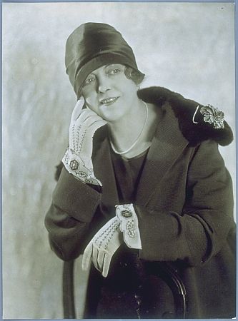 Rosa Porten 1926 in einem Ensemble, bestehend aus einem dunklen Mantel aus Rips mit einem Pelzkragen, einem dunklen Topfhut aus Satin und hellen bestickten Stulpenhandschuhen der Gebrder Biker; Urheber: Foto-Atelier "Becker und Maass" (Otto Becker (18491892)/Heinrich Maass (18601930)); Quelle: "Staatliche Museen zu Berlin", Kunstbibliothek (Ident. Nr.: 14132571); Lizenz: CC BY-SA 4.0