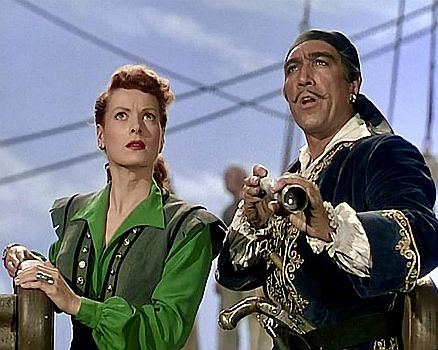 "Gegen alle Flaggen"(1952, "Against All Flags"): Szenenfoto mit Maureen OHara als die feurige Piratin Petunia Stevens, die sich in den Offizier der Kriegsmarine, Brian Hawke (Errol Flynn), verliebt, und Anthony Quinn als Bandenchef Captain Roc Brasiliano; mit freundlicher Genehmigung von "Pidax Film", welche das Abenteuer Mitte Mai 2025 auf DVD herausbrachte.