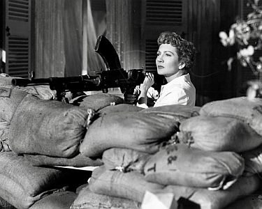 "Weiße Frau im Dschungel"4) (1952, "The Planter’s Wife"): Szenenfoto mit Claudette Colbert als wehrhafte Liz Frazer; mit freundlicher Genehmigung von Pidax-Film, welche das Abenteuer am 09.04.2021 auf DVD herausbrachte.