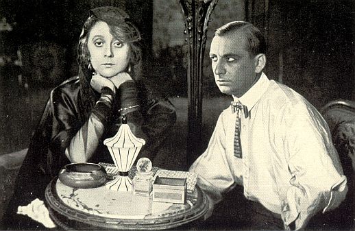 Curt Goetz als Detektiv Joe Deebs und Gertrud Welcker als Gräfin Katja von Falkenhorst in dem Stummfilm "Die Damer in Schwarz" (1920) von Victor Janson für die Berliner "Projektions-AG Union" (PAGU); Quelle: virtual-history.com aus "Vom Werden deutscher Filmkunst/1. Teil: Der stumme Film" von Dr. Oskar Kalbus (Berlin 1935, S.27); Lizenz: gemeinfrei