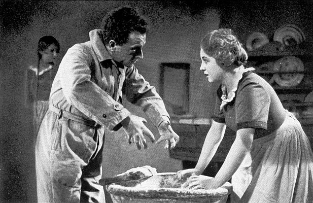 Regisseur Karl Grune zeigt Camilla von Hollay bei den Dreharbeiten zu dem Stummfilm "Am Rande der Welt" (1927) wie man Teig knetet. Hier mimte sie die Ehefrau von Johannes (Wilhelm Dieterle), dem ersten Sohn des Müllers (Albert Steinrück); Quelle: virtual-history.com aus "Vom Werden deutscher Filmkunst/1. Teil: Der stumme Film" von Dr. Oskar Kalbus (Berlin 1935, S. 100); Urheber: Unbekannt; Lizenz: gemeinfrei