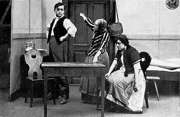 Szene (v.l.n.r.) mit Ernst Rckert (der Bruder), Frida Richard (die Mutter), Sabine Impekoven (die Ehefrau) aus dem Stummfilm "Wie die Bltter" (1913); Regie: Otto Rippert fr die Berliner "Continental-Kunstfilm"; Quelle: virtual-history.com aus "Vom Werden deutscher Filmkunst/1. Teil: Der stumme Film" von Dr. Oskar Kalbus (Berlin 1935, S.14): Lizenz: gemeinfrei