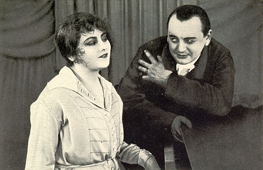 Szene mit Lilly Flohr und Reinhold Schnzel aus dem Stummfilm "Das Mdchen aus der Ackerstrasse", Teil 1: "Ein Drama aus der Großstadt" (1920); Quelle: virtual-history.com aus "Vom Werden deutscher Filmkunst/1. Teil: Der stumme Film" von Dr. Oskar Kalbus (Berlin 1935, S. 41); Lizenz: gemeinfrei