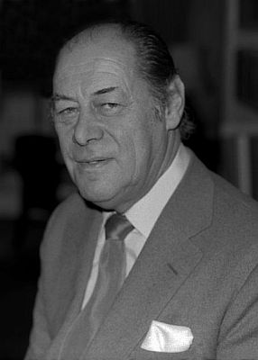 Portrait von Rex Harrison 1976 in seiner  Wohnung im Londoner Stadtteil Belgravia; Urheber: Allan Warren (britischer Fotograf; www.allanwarren.com); Lizenz: CC BY-SA 3.0; Quelle: Wikimedia Commons