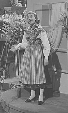 Alice Babs 1958 beim "Grand Prix Eurovision de laChanson"; Quelle: wiki.beeldengeluid.nl (Ausschnitt des Originalfotos); Archief Beeld en Geluid, Bestand: 58078N-65.png; Urheber: "Nederlandse Televisie Stichting"1) (NTS), Vorgnger der "Nederlandse Omroep Stichting" (NOS); Lizenz: CC BY-SA 3.0 NL bzw. Licentie Beeld en Geluidwiki