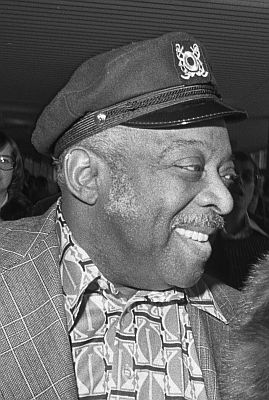 Count Basie kommt am 4. Oktober 1975 auf dem Flughafen Amsterdam Schiphol an. Rechteinhaber: Nationaal Archief&nbsp;(Den Haag, Rijksfotoarchief; Bestandsnummer: 928-1863); Urheber/Fotograf: Rob Mieremet / Anefo; Quelle: Wikimedia Commons (Ausschnitt des Originalfotos); Lizenz: CC0 1.0 (Verzicht auf das Copyright)