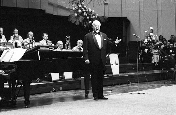 Kurt B�hme am 19. Oktober 1974 bei seinem Auftritt im "Kieler Schloss" anl�sslich des Wohlt�tigkeitsball des "Deutschen Roten Kreuzes" (DRK), begleitet von dem "NDR�Tanzorchester"; Urheber: Friedrich Magnussen (1914�1987); Quelle: Bildnachlass Friedrich Magnussen (KN, 21.10.1974); Rechteinhaber: Gesellschaft f�r Kieler Stadtgeschichte/Stadtarchiv Kiel; Lizenz: CC BY-SA 3.0 DE; Quelle: Wikimedia Commons