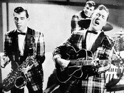 Bill Haley&The Comets etwa 1955 whrend eines Fernsehauftrittes; Urheber: Unbekannt; Foto mit freundlicher Genehmigung von Mr. Klau Klettner von "Hydra Records" verffentlicht bei Wikimedia Commons bzw. Wikipedia