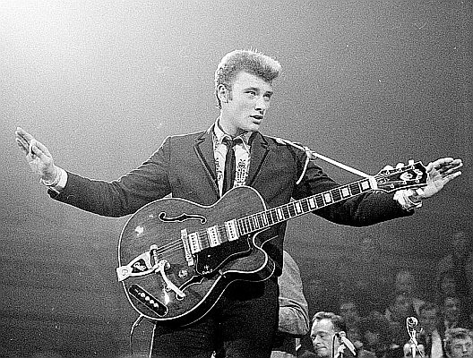 Johnny Hallyday am 31. M�rz 1963 bei einer Show in den Niederlanden; Urheber: "Fotopersbureau De Boer"; Lizenz: CC0 1.0 (Verzicht auf das Copyright); Ausschnitt des Originalfotos bei (Quelle): Wikimedia Commons von "Noord-Hollands Archief"; (Inventar-Nr. NL-HlmNHA_1478_00710K02_08)