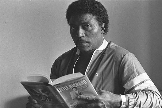 Little Richard liest 1984 in seiner Biografie: Quelle: Wikimedia Commons von "UCLA Library Digital Collection";&nbsp;Urheber: Ian Dryden/"Los Angeles Times"; Lizenz: CC BY 4.0 Deed