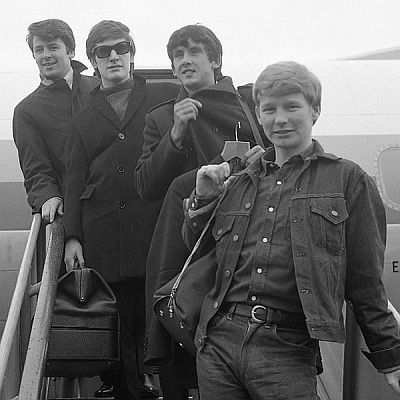 "The Searchers" (Mike Pender, Chris Curtis, Frank Allen, John McNally) am 17. September 1965 bei Ankunft auf dem Amsterdamer Flughafen Schiphol; Rechteinhaber: Nationaal Archief (Den Haag, Rijksfotoarchief; Bestandsnummer: 918-1993); Urheber/Fotograf: Jac. de Nijs / Anefo; Quelle: Wikimedia Commons; Lizenz:www.gahetna.nl/over-ons/open-data / CC BY-SA 3.0 NL